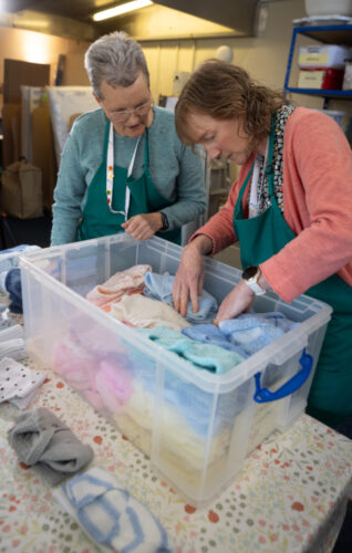 An image of 2 volunteers packing a box.