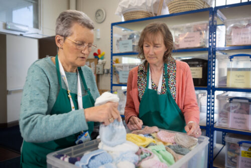 A photo of 2 ladies packing a box